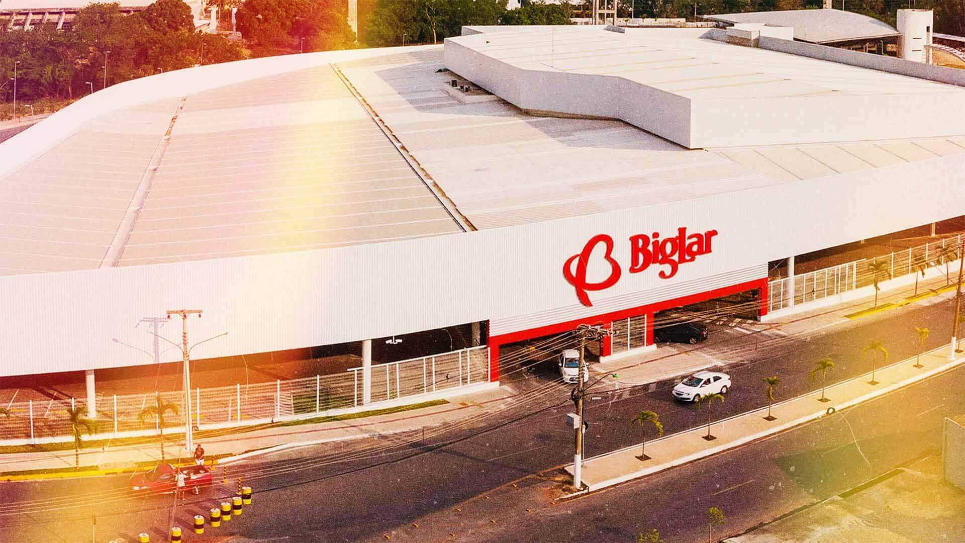 Estrutura do supermercado Big Lar com logo em vermelho acima da entrada e saída do estacionamento