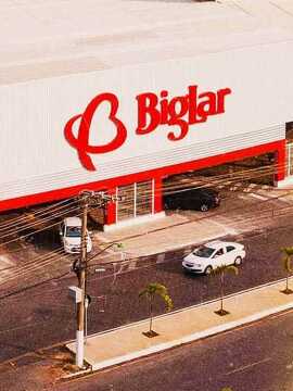 Estrutura do supermercado Big Lar com logo em vermelho acima da entrada e saída do estacionamento