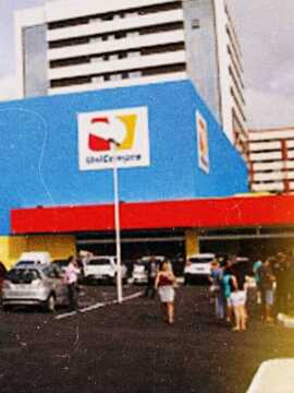 Estacionamento com prédio do UniCompra ao fundo