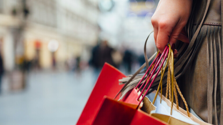 pessoa andando com sacola de compras.