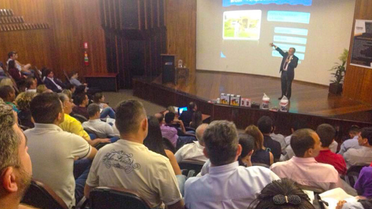 Pessoas num auditório assistindo uma palestra.