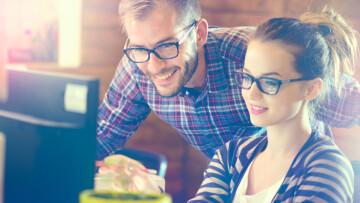 duas pessoas trabalhando no computador.