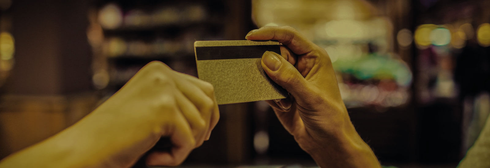 Foco na mão de duas pessoas que estão segurando um cartão.